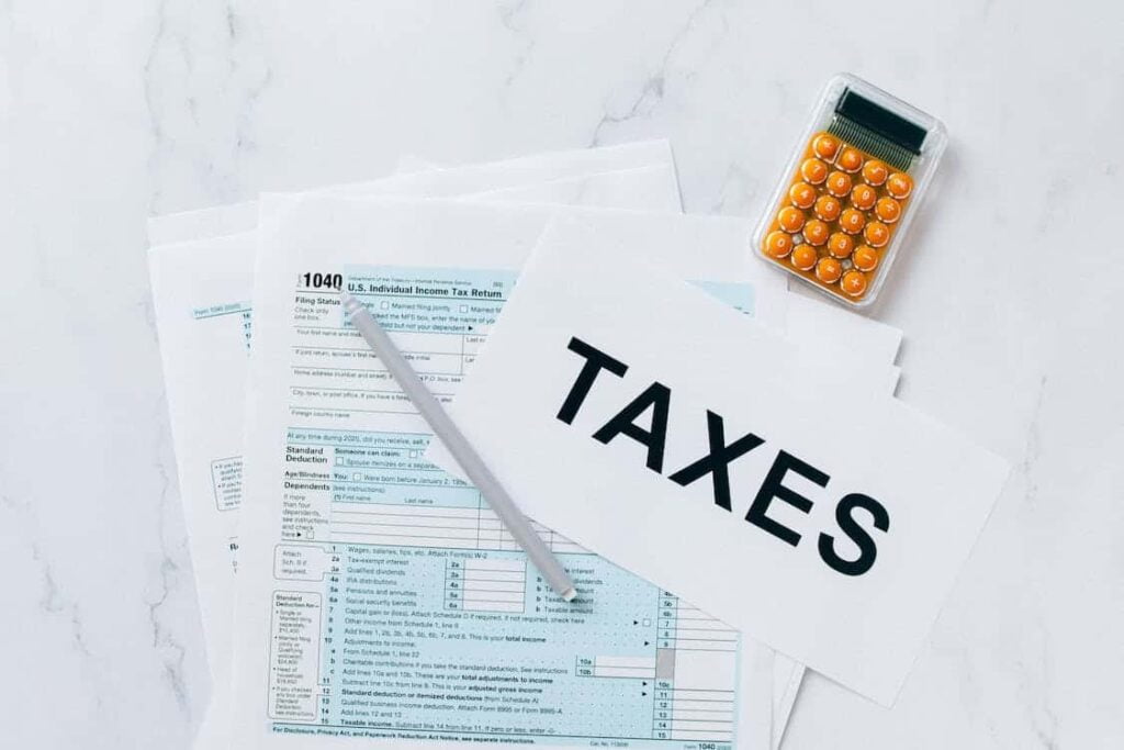 U.S. tax forms, calculator, and "TAXES" sign, illustrating key person insurance taxation updates for businesses.