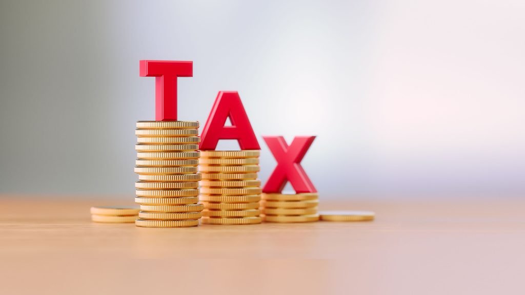 Stack of gold coins with bold red letters spelling "TAX," symbolizing tax implications for shareholders and business continuity.